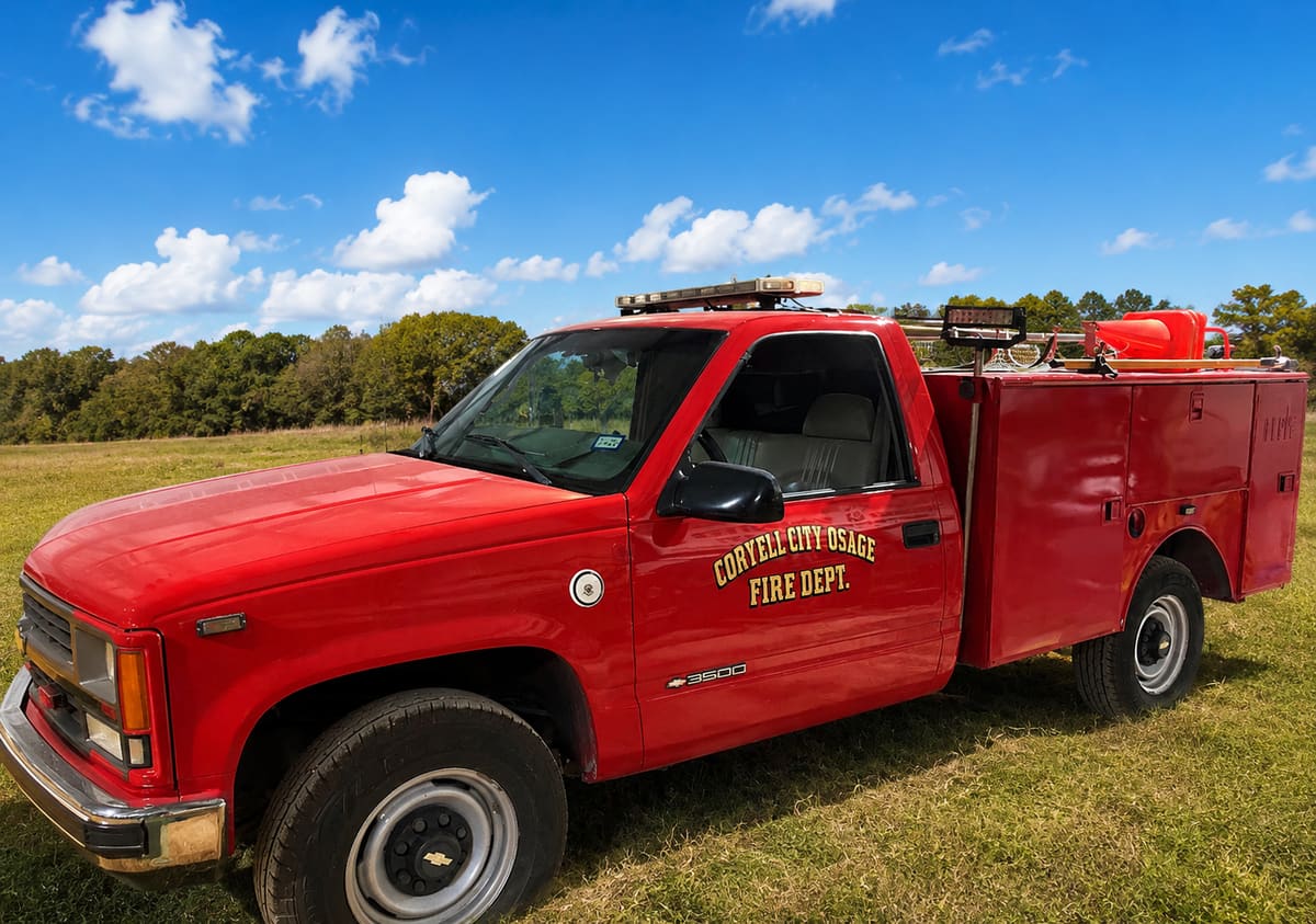 Utility 40, a white CCOVFD crew-cab pickup truck with a red stripe and department crest, parked outside the station